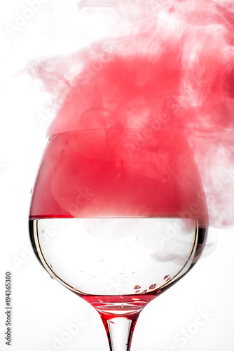 Wine glass with red smoke inside