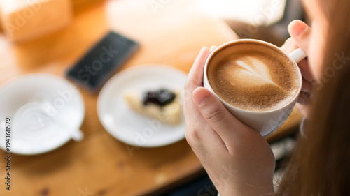 Woman hands take a coffee in coffee cafe