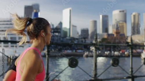 Young female jogger running with the city in the background, in slow motion