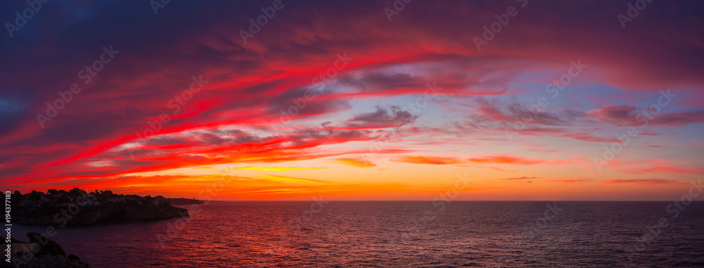 Fototapeta premium Drone aerial view of a Fiery sunrise with multicolored clouds. Mallorca Island, Spain. Summer season