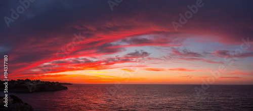 Fototapeta Naklejka Na Ścianę i Meble -  Drone aerial view of a Fiery sunrise with multicolored clouds. Mallorca Island, Spain. Summer season