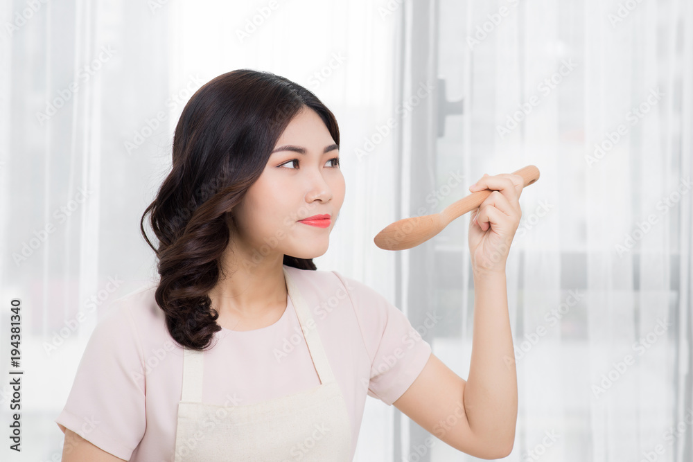 Healthy food. Asian woman cooking in the kitchen with wooden spoon Healthy food. Asian woman cooking in the kitchen with wooden spoon