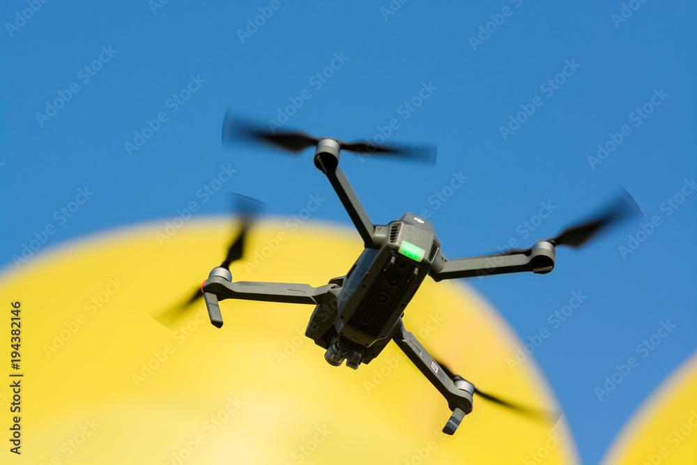 flying drone with yellow balloon and blue sky background flying drone with yellow balloon and blue sky background