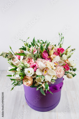 beautiful bouquet of mixed flowers in a vase on wooden table. the work of the florist at a flower shop