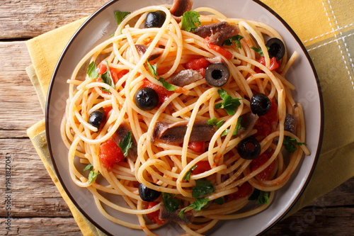 Pasta Alla Puttanesca with anchovies and black olives. horizontal top view