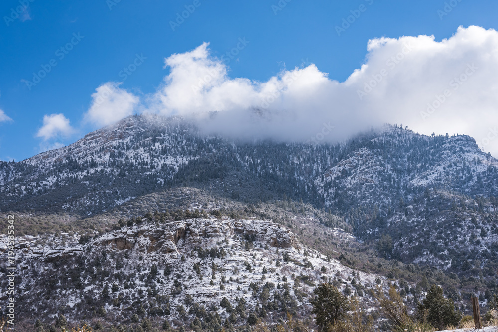 View of the snowy mountain with clouds around it