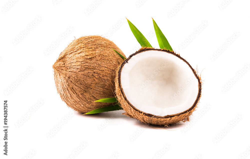 Coconut with half andgreen leaves on white background.
