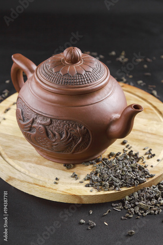 Clay teapot and scattered tea on the table