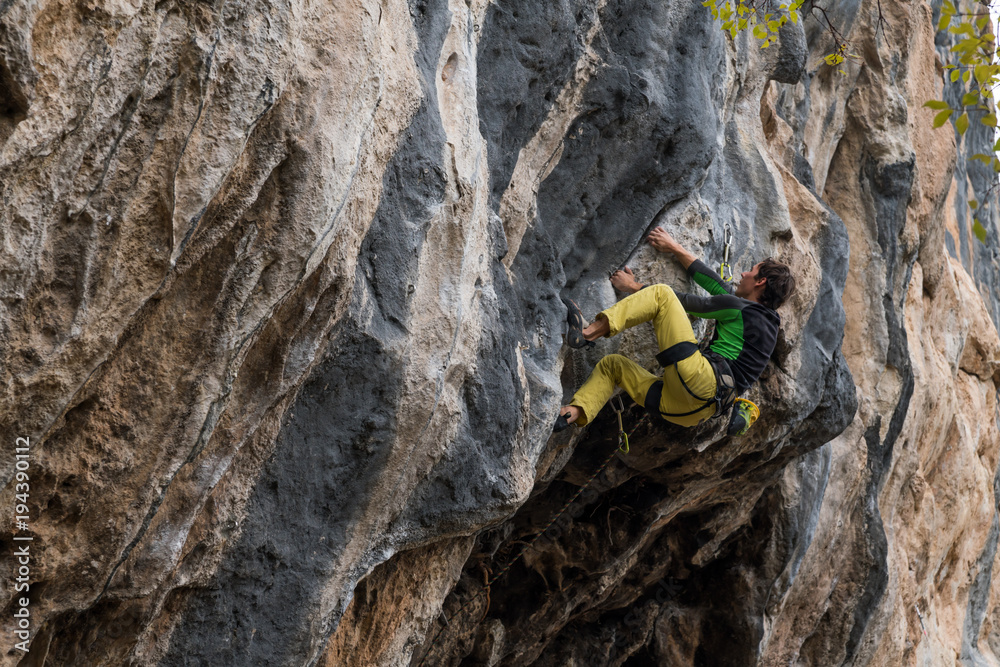Men climbs a rock with a rope, lead