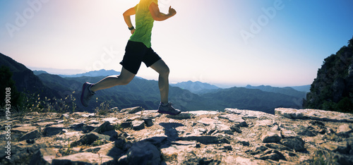 sporty fitness woman runner running on mountain top photo