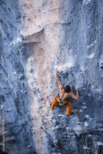 Fototapeta Naklejka Na Ścianę i Meble -  Bare torso men climbs a tufa rock with a rope, lead, Turkey