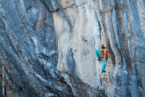Blonde girl climbs tufa rock, Chitdibi, Turkey
