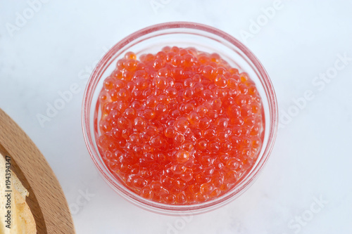 red caviar in a transparent glass bowl.