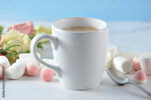 cappuccino inwhite mug with flowers and marshmallow photo