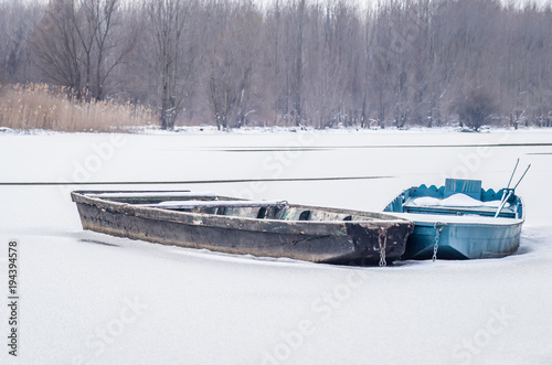 Abandoned boats on the shore of the lake in the winter