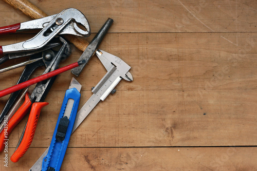 Construction tools on a rustic wood background