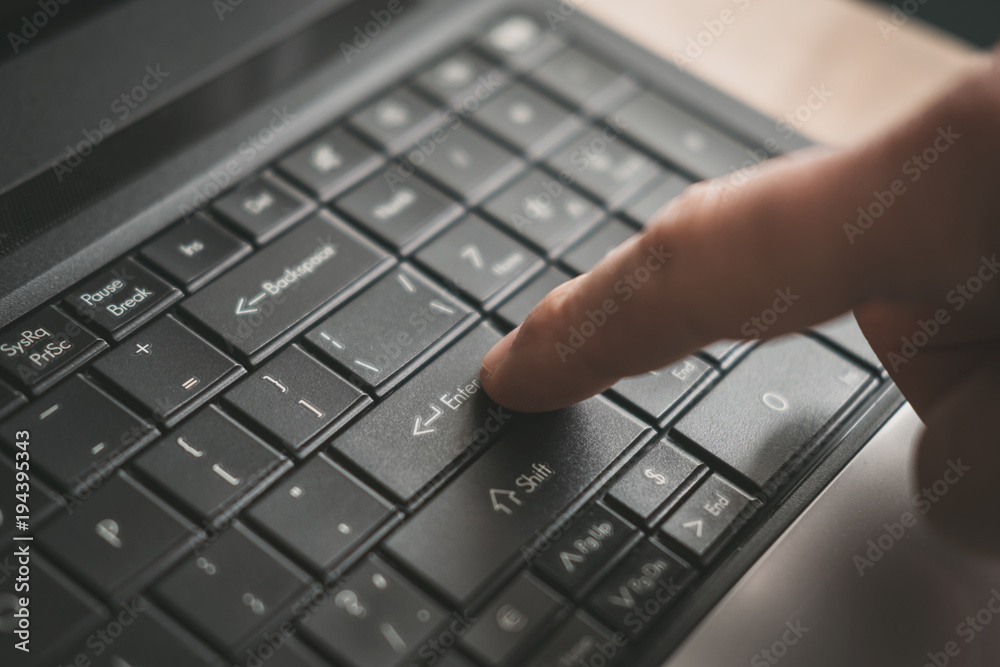 finger of a man clicks on a computer keyboard buttons a toned background finger of a man clicks on a computer keyboard buttons a toned background