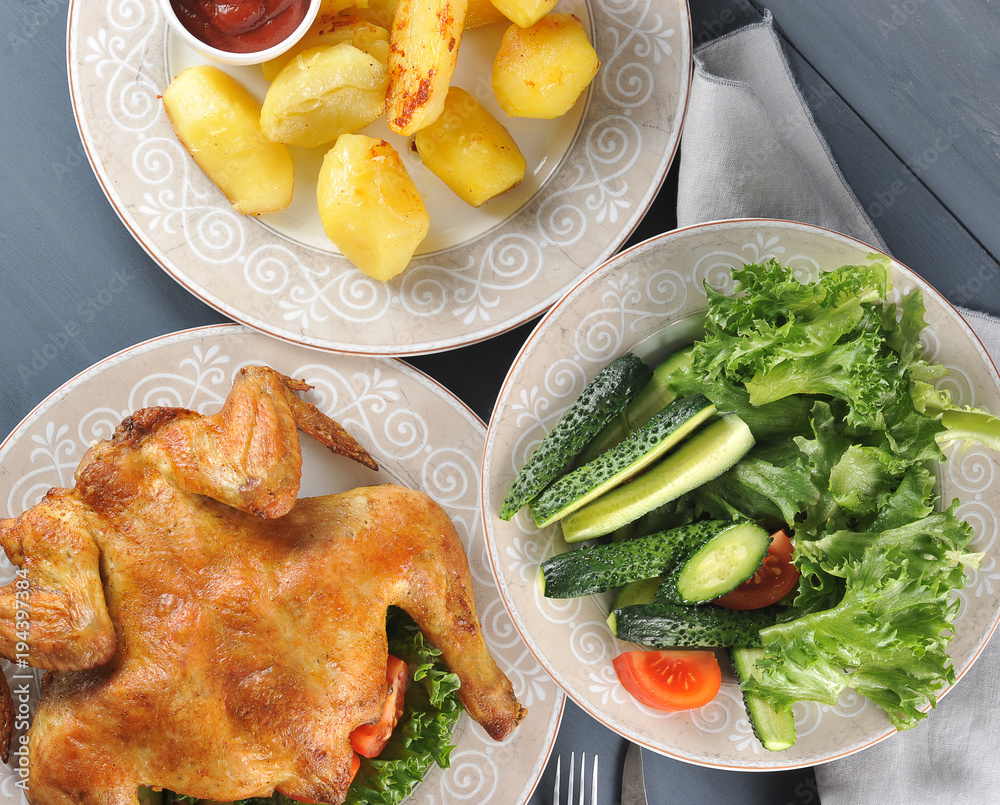 fried chicken, fried potatoes with ketchup and a salad of fresh vegetables