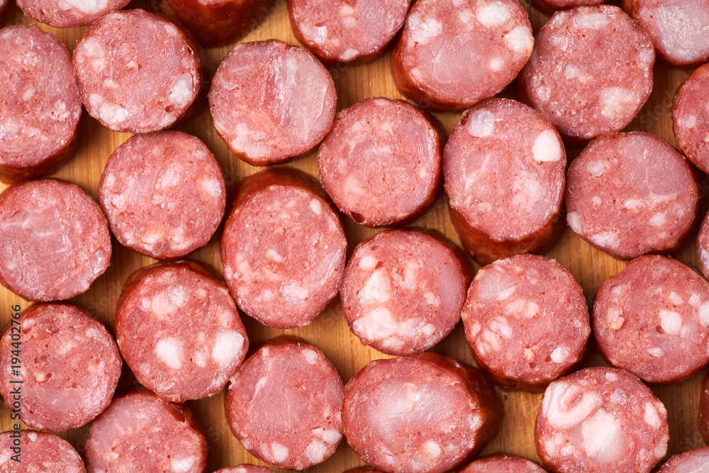 Sausage cut into rings on a wooden background. Sausage cut into rings on a wooden background.