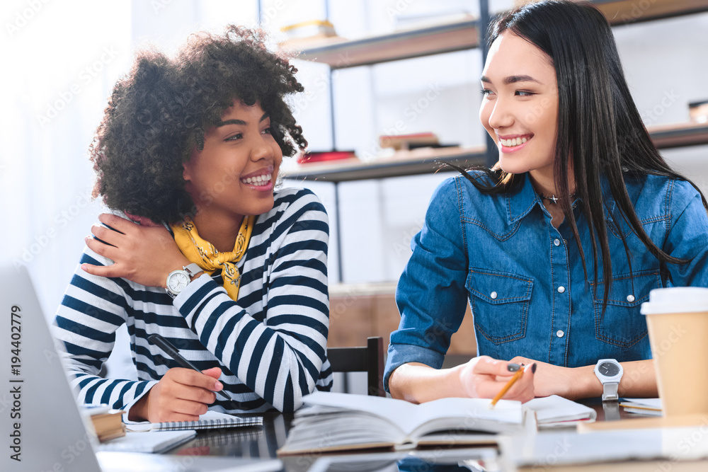portrait of cheerful multiracial students doing homework together portrait of cheerful multiracial students doing homework together
