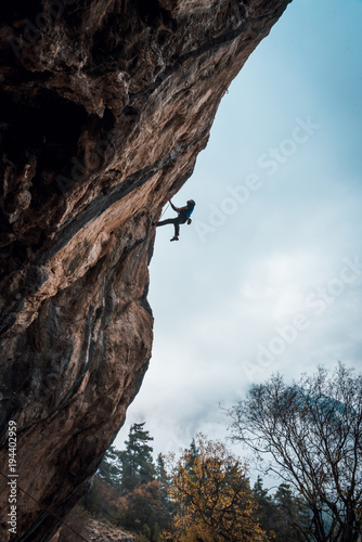 Silhouette of a person climbing an overhanging rock with a rope, lead. Chitdibi, Turkey