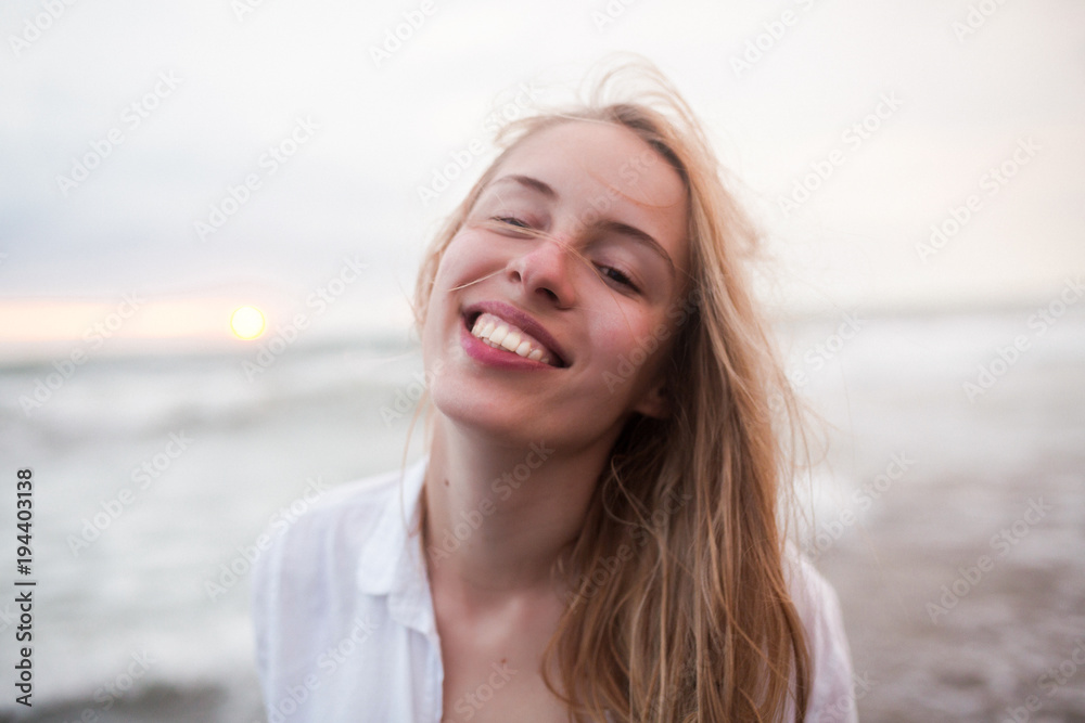 Outside portrait of romantic sensitive woman with long blonde hair and wonderful smile walks down by ocean and enjoys of vacation, true emotions Outside portrait of romantic sensitive woman with long blonde hair and wonderful smile walks down by ocean and enjoys of vacation, true emotions