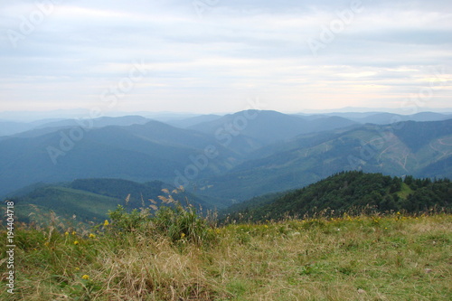 The landscape of the Ukrainian Carpathians against the background of the evening cloudy sky from the height of the highest peak of the mountain range. © Hennadii