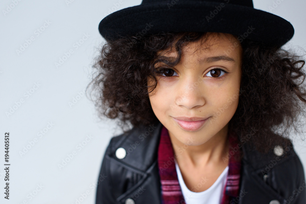 close-up portrait of beautiful little child in leather jacket and hat looking at camera isolated on grey close-up portrait of beautiful little child in leather jacket and hat looking at camera isolated on grey