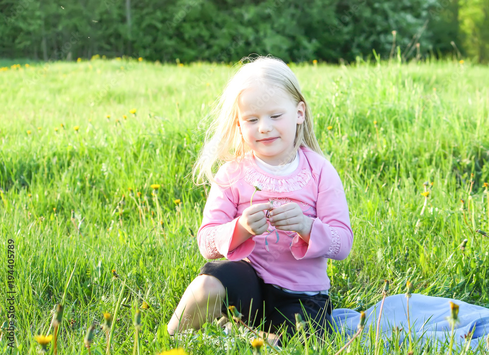 Fototapeta premium Cute little girl on the meadow in summer day
