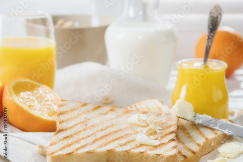 Delicious breakfast, french toasts with butter and honey, fresh oranges and juice.