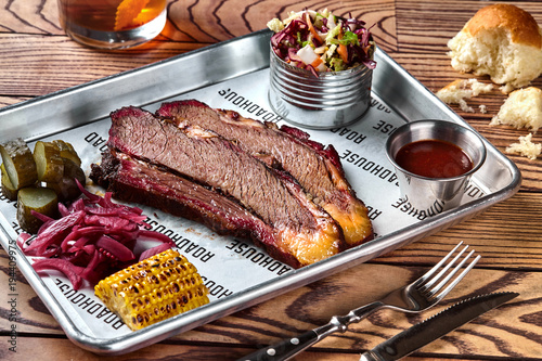 Bilde på lerret Smoked barbecue beef brisket with sauce, corn, marinated cucumber and onions