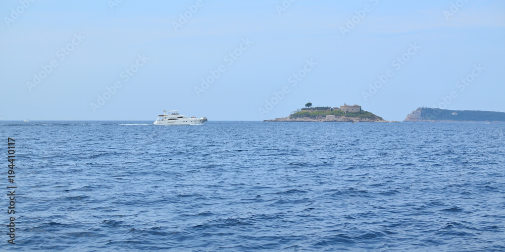 Tourist boat sailing on a sea and passing by an island