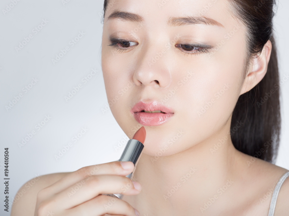 口紅を塗っている若い女性 口紅を塗っている若い女性