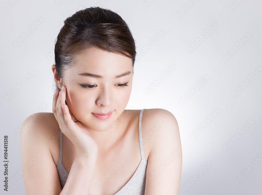 頰に手を当てて肌のチェックをする女性 頰に手を当てて肌のチェックをする女性