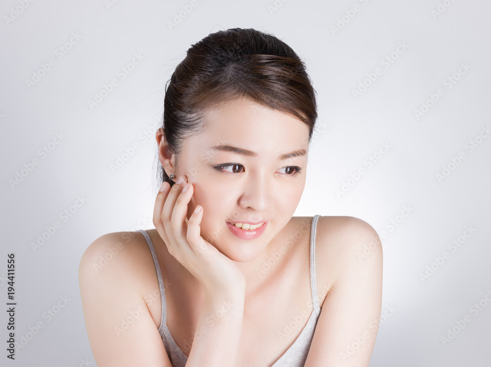 頰に手を当てて肌のチェックをする女性