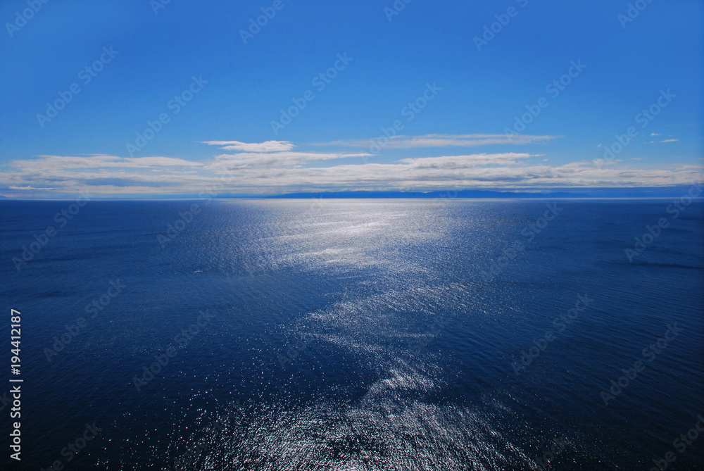 Синяя гладь воды до горизонта с голубым небом 