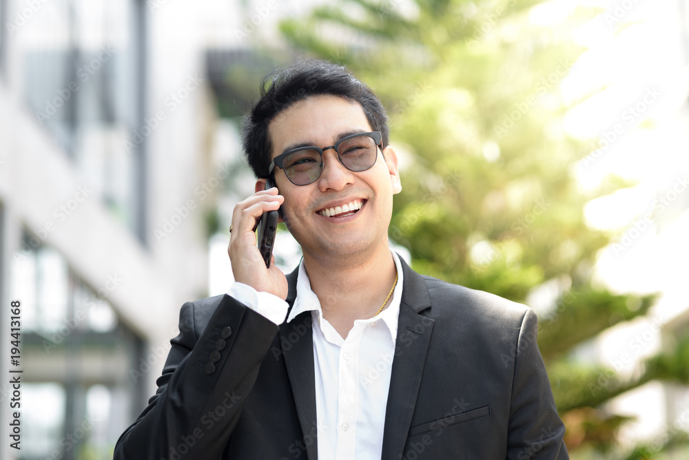 Handsome Asian businessman taking with phone outdoor. Handsome Asian businessman taking with phone outdoor.