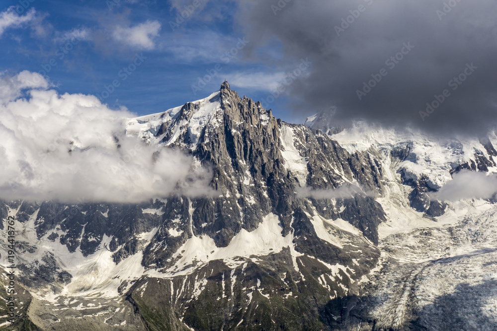 The beautiful scenery of the Aiguille du Midi and the glacier between the clouds. Mont Blanc massif.
