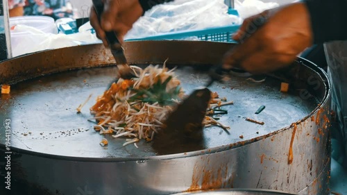 Seller of street food fries traditional thai rice noodles with eggs, chicken and sprouts. Asian street food
