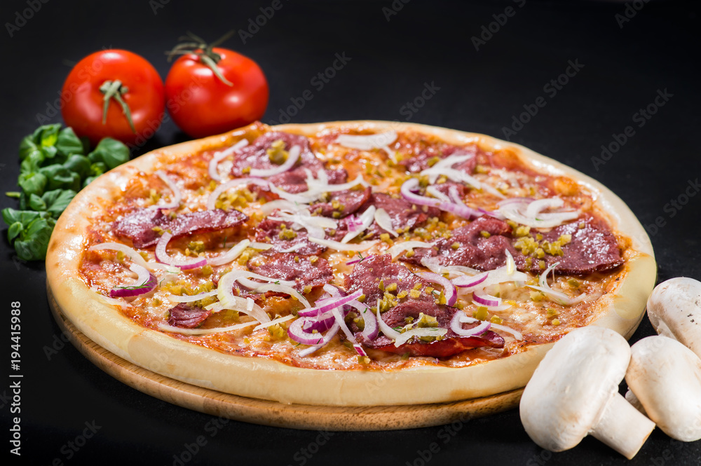 Delicious tasty Diablo pizza with mozzarella, beef, onion, pepper and sauce on wooden board on dark background