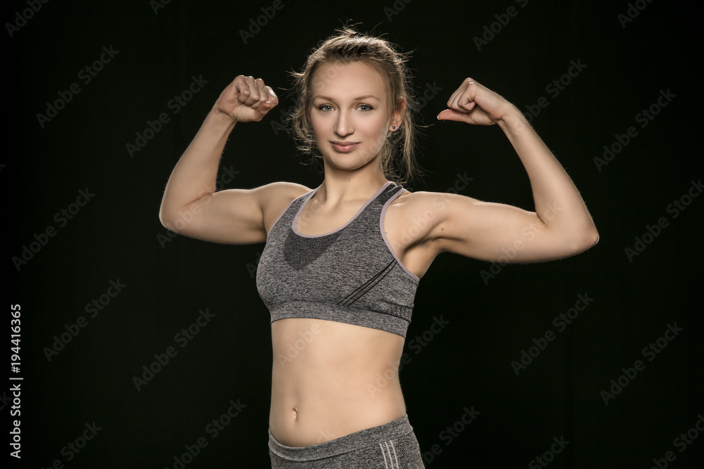 Obraz premium athletic woman shows her muscles, side view