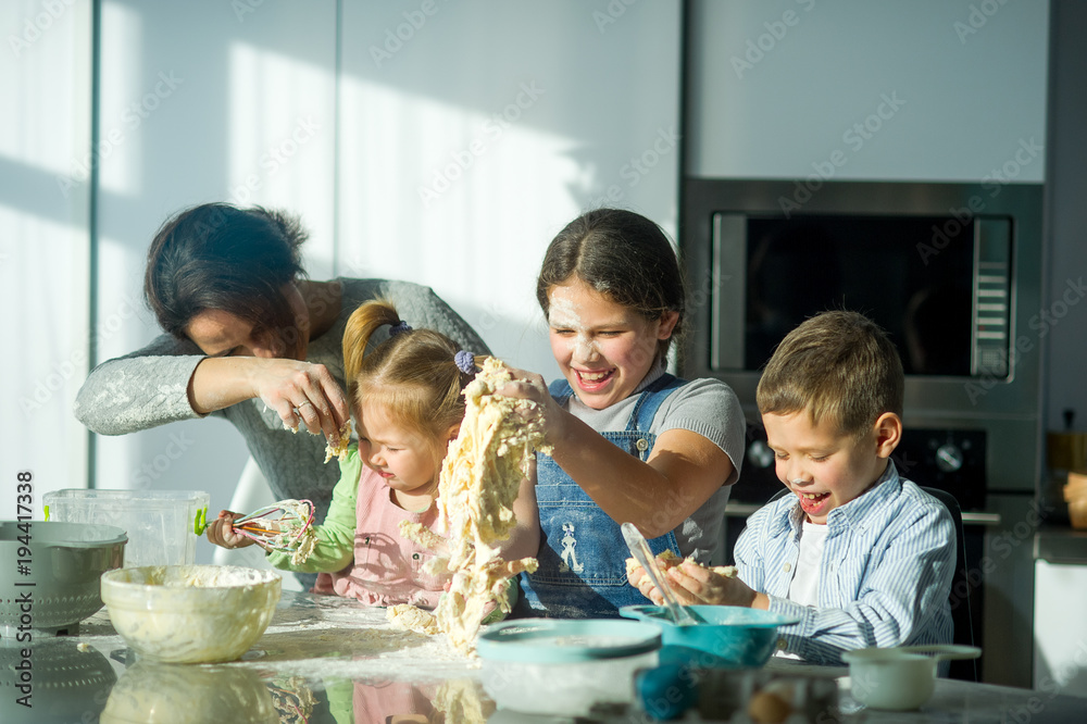 Mother teaches her three children to cook. Mother teaches her three children to cook.