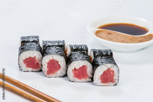 Fresh delicious Japanese sushi with tuna on light background