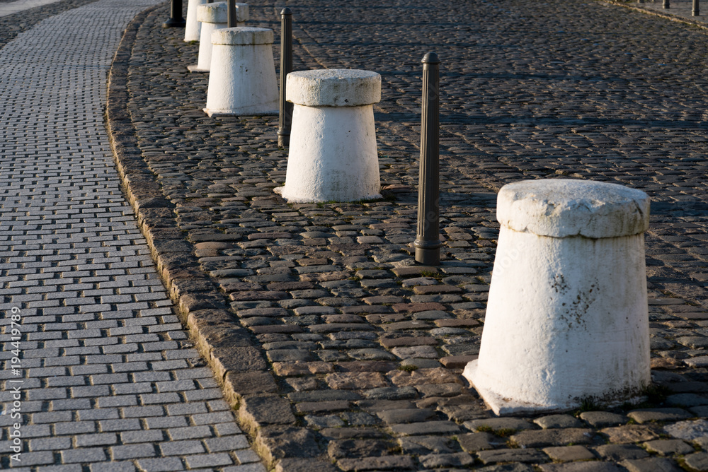 Paved stone road with concrete ans steel security posts Paved stone road with concrete ans steel security posts
