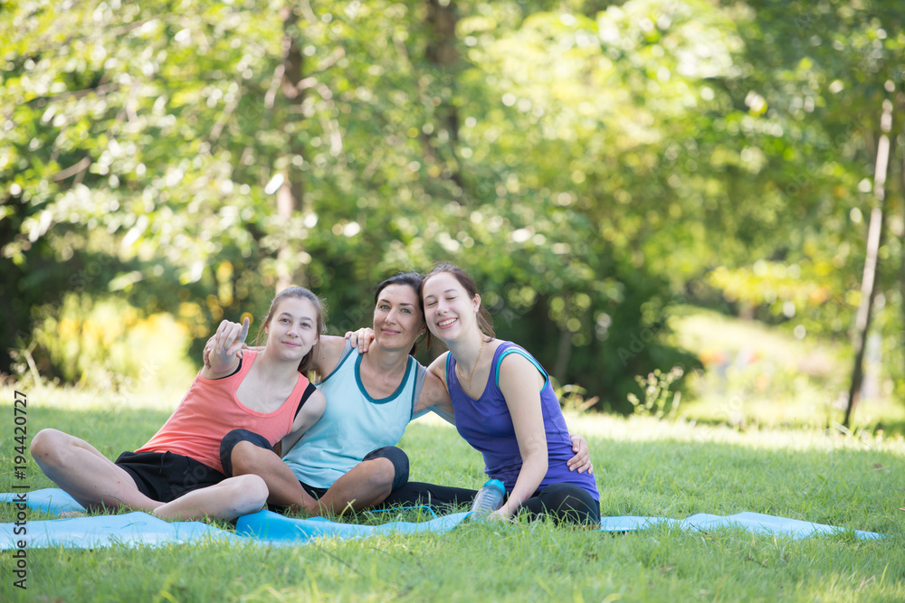Families with young Russian mother and daughter hugged each other with joy after practicing yoga at the park finished. Health and Fitness concept. Families with young Russian mother and daughter hugged each other with joy after practicing yoga at the park finished. Health and Fitness concept.
