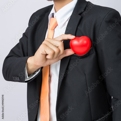Businessman holds out the  red heart, isolated background © PRASERT