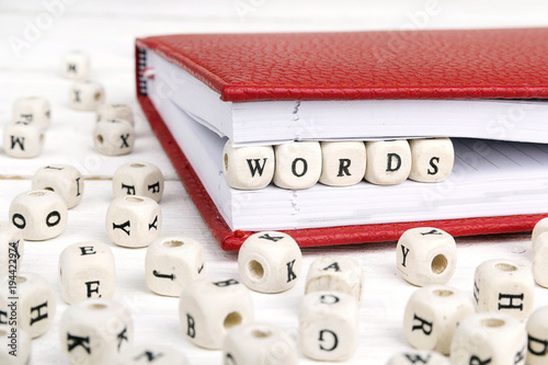 Word Words written in wooden blocks in red notebook on white wooden table. photo