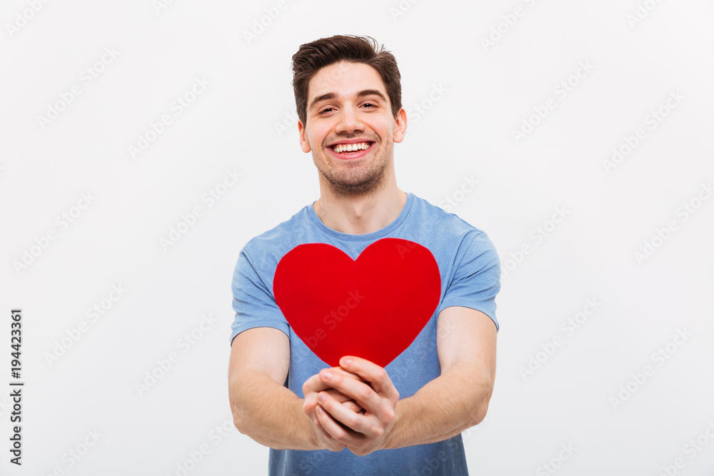 Image of Happy man in t-shirt giving paper heart Image of Happy man in t-shirt giving paper heart