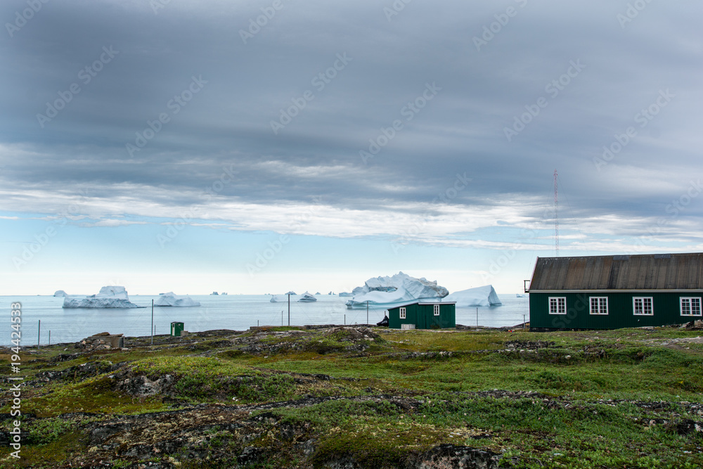 Icebergs in Greenland. Village and icebergs.