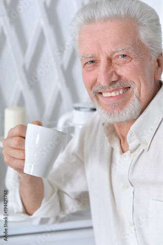 smiling senior man drinking tea at home 